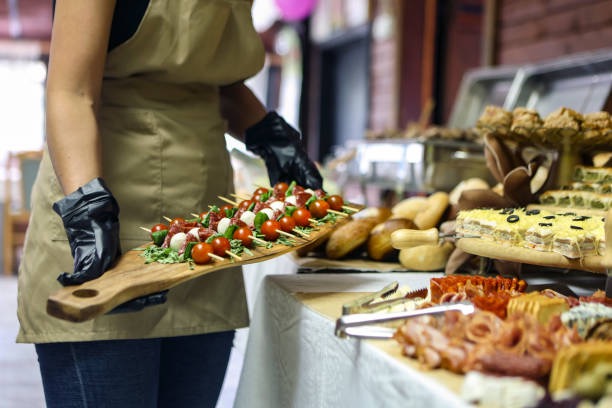Server carrying a caprese platter at a catered event